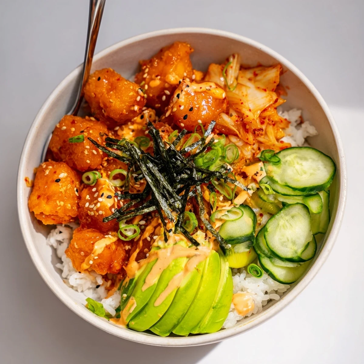 Crispy Salmon Rice Bowl topped with creamy spicy mayo and fresh avocado slices.