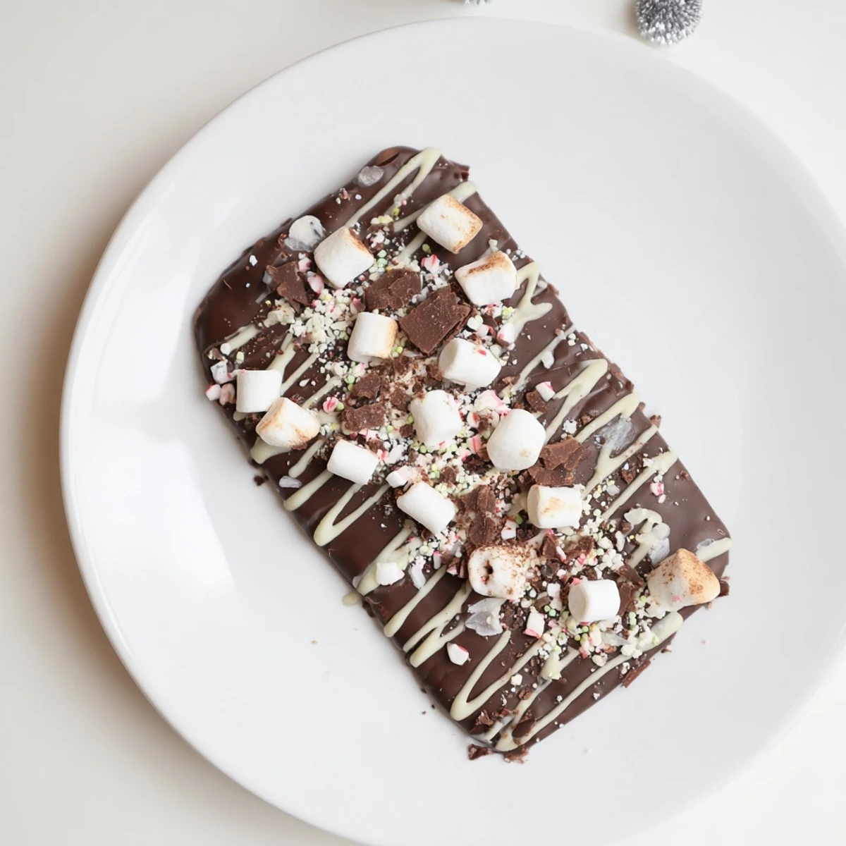 Melted semi-sweet chocolate spread with hot cocoa mix makes a delicious Hot Chocolate Bomb Bark.