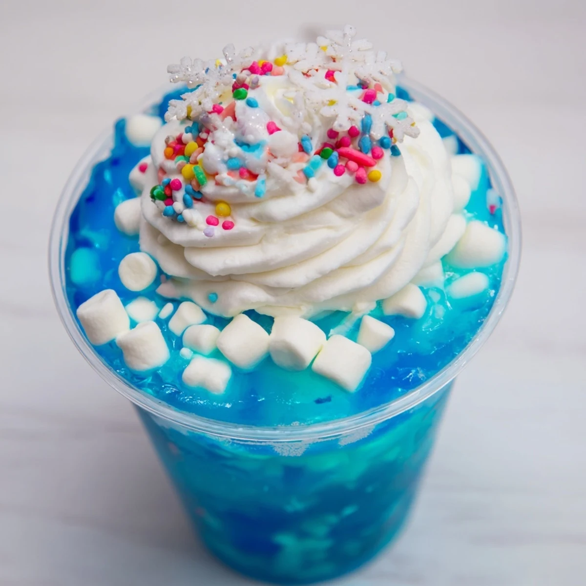 Refreshing snow globe Jello cups, perfect for parties, show off colorful layers with playful decorations.