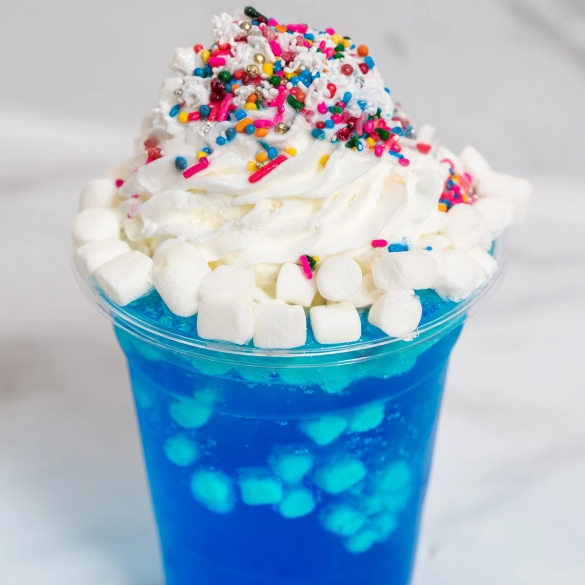 These enchanting snow globe Jello cups feature a playful, colorful display of gelatin, sprinkles, and marshmallows.