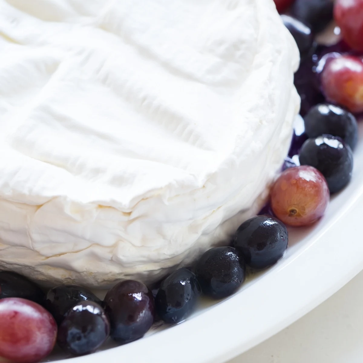 Floating Island appetizer: a creamy cheese wheel “island” floating on vibrant blue yogurt.