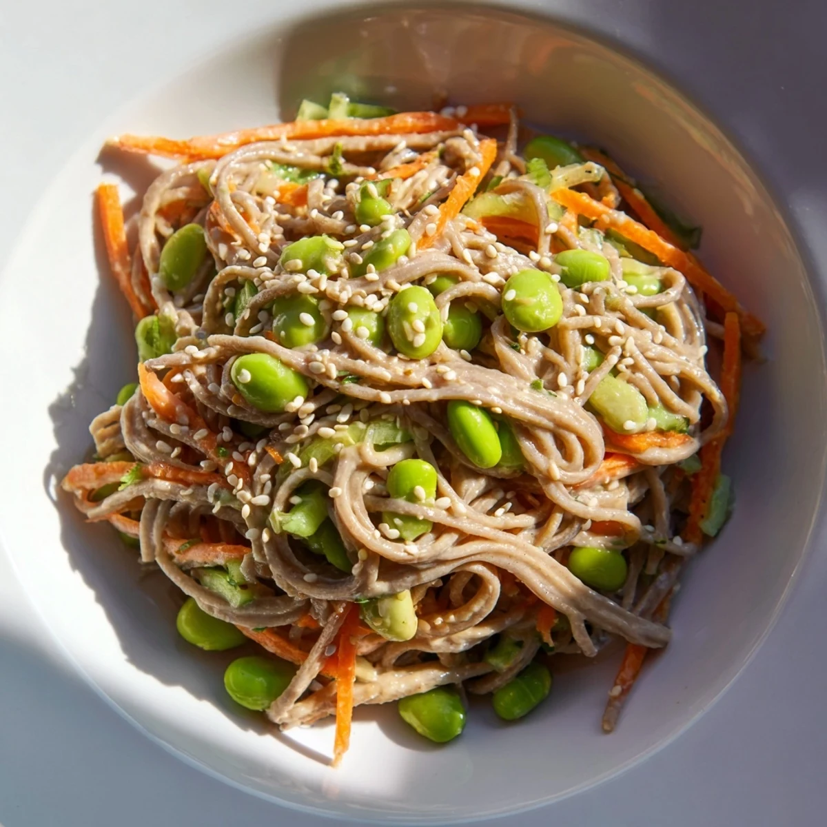 Close-up of a creamy, delicious Asian Sesame Noodle Salad, showcasing fresh vegetables and savory dressing.
