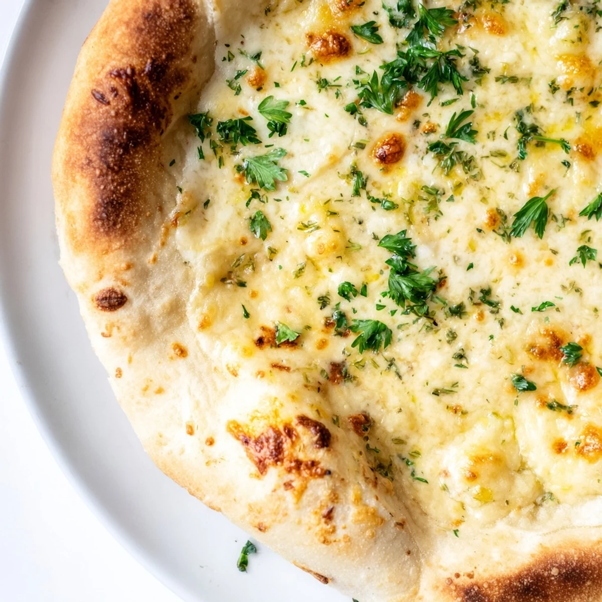 Freshly baked Creamy Garlic White Pizza with bubbly mozzarella on a golden, crisp crust, sliced and ready to serve.
