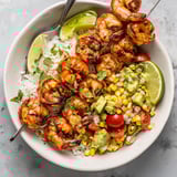 Juicy grilled shrimp and creamy avocado corn salsa over warm fluffy rice.  