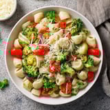 Steaming bowl of ditalini pasta with air-fried vegetables, ready for a delicious vegetarian meal.