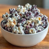 A large bowl of freshly made Black Currant Cheesecake Kettle Corn, perfect for a gourmet movie night snack.