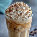 Creamy vanilla bean frappuccino protein shake with whipped cream and a sprinkle of cinnamon, perfect for a quick, energizing treat.