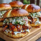 Juicy BBQ chicken sliders with coleslaw, tender pulled chicken in sweet and smoky sauce, served on slider buns with crunchy cabbage-carrot slaw, perfect for July celebrations.