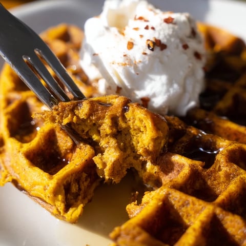 Warm Spicy Pumpkin Buttermilk Waffles topped with maple syrup for a cozy morning treat.
