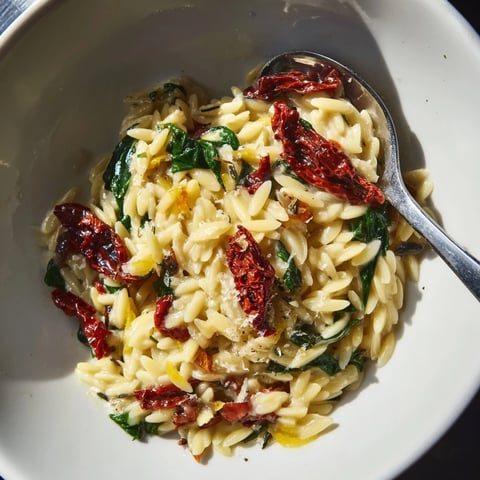 A comforting creamy Tuscan Orzo bowl with vibrant spinach and sun-dried tomatoes.  