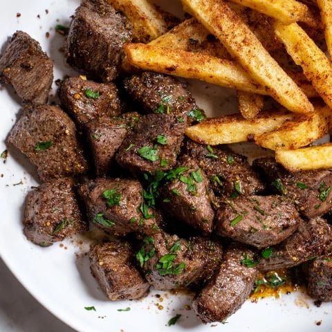 Sizzling Blackened Cajun Steak Bites with crisp fries, offering a flavorful, juicy bite ready to be enjoyed.