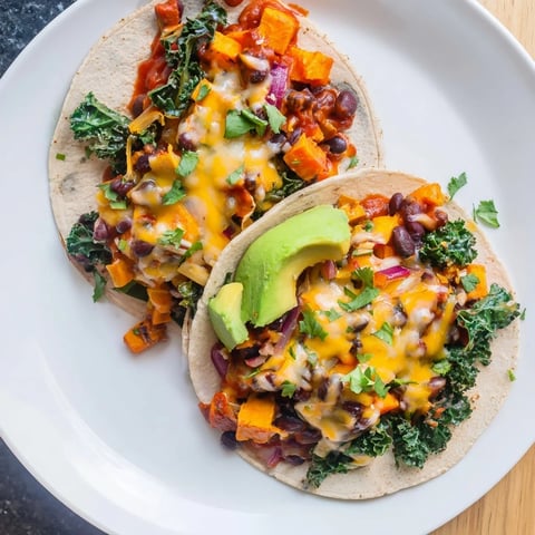 Golden-brown edges on the one-pan sweet potato, black bean & kale enchiladas, ready to serve with fresh garnishes.