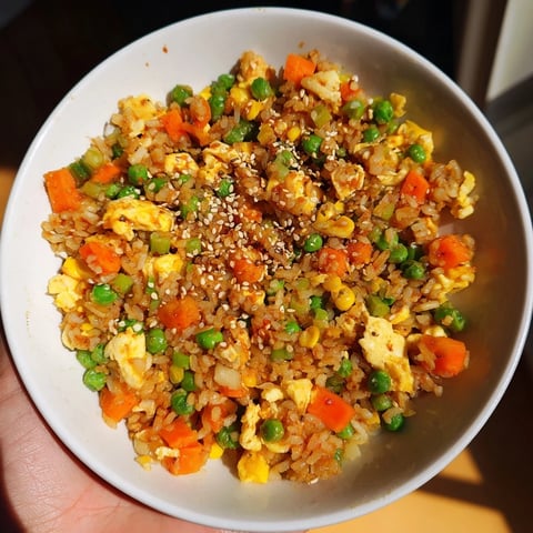 Golden-hued, steamy Frozen Veggie Fried Rice with fluffy eggs and vegetables ready to serve for dinner.
