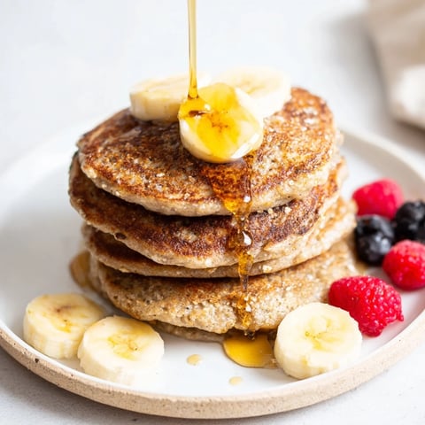 Golden, bubbly banana oat pancakes ready to be flipped on the griddle; a perfect breakfast!