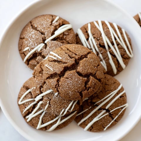 Warm gingerbread latte cookies with a white chocolate drizzle, ready for a winter treat.
