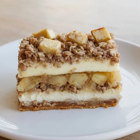 Golden-brown Apple Crisp Cheesecake Bars, a delightful dessert with a perfect creamy, fruity, and crispy texture.