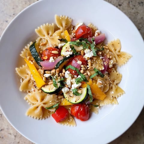 Vibrant platter of Festive Bow Tie Pasta, showcasing colorful roasted vegetables and creamy feta cheese.