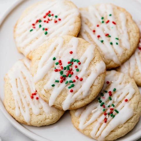 Golden, buttery Holiday Cookies with Icing Drizzle, decorated with a sweet, festive icing and sprinkles.
