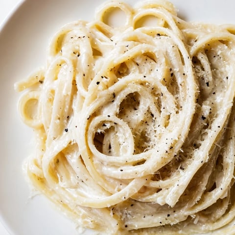 Creamy, golden Lazy Girl Three-Ingredient Pasta glistening after being tossed with Parmesan.