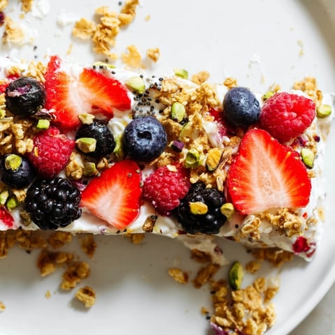 Vibrant frozen fruit yogurt bark with colorful berries and crunchy granola, perfect treat.