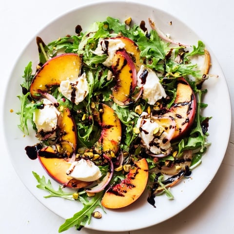 Grilled Peach Salad with charred peaches, creamy burrata, and peppery arugula, ready to enjoy.