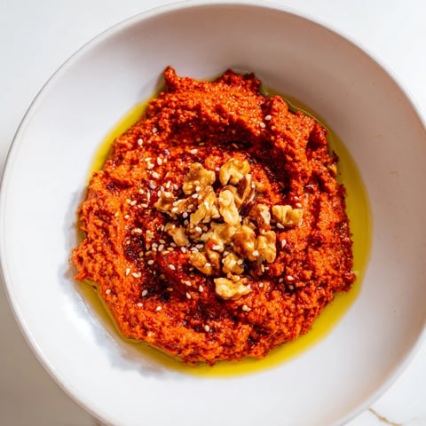 Vibrant Syrian Muhammara dip, a blend of roasted red peppers and walnuts, ready to eat.