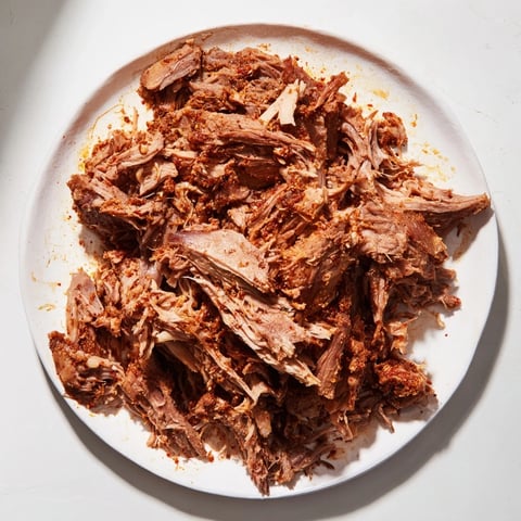 Tender Omani Shuwa, slow-cooked lamb shoulder encased in banana leaves, ready to be shredded.