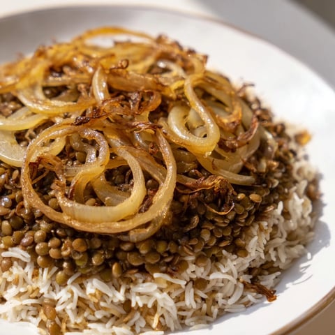 Golden caramelized onions atop hearty Lebanese Mjadra, a flavorful lentil and rice dish.
