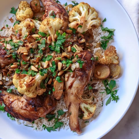 A steaming plate of Maklouba, a Middle Eastern dish with fluffy spiced rice and tender chicken.