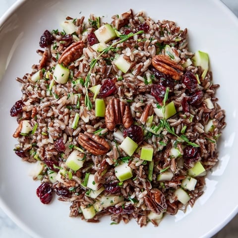 A colorful bowl of Wild Rice Harvest Salad with cranberries and toasted pecans, ready to enjoy.