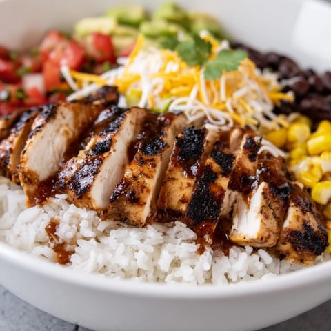 Spicy Chicken Burrito Bowl with grilled chicken, rice, black beans, and corn topped with zesty salsa and avocado.  