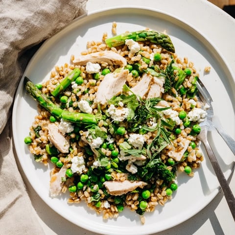 Warm Spring Farro Chicken Salad with tender grains, juicy chicken, crisp asparagus, peas, and arugula tossed in bright lemon vinaigrette.