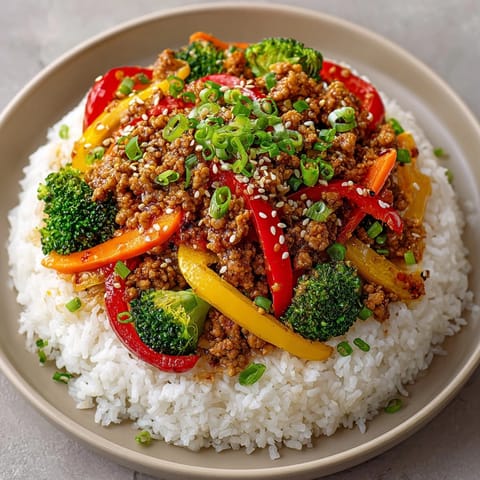 Steaming jasmine rice is topped with colorful vegetables and savory turkey in this comforting Weeknight Honey-Garlic Turkey & Rice Bowls recipe.