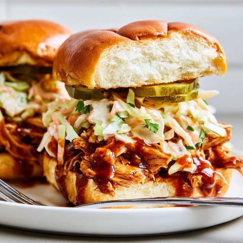 Golden, toasted slider buns hug BBQ chicken: delicious Cajun BBQ Chicken Sliders recipe.