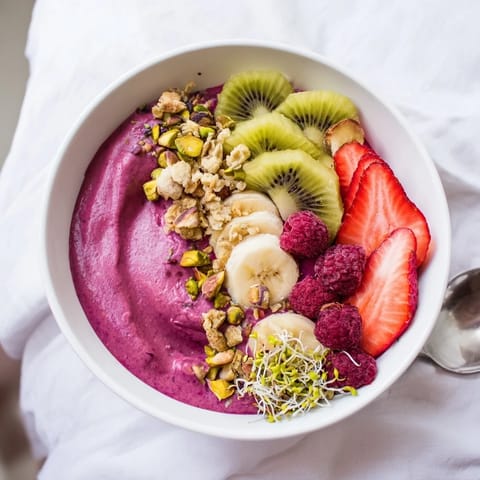 Delicious smoothie bowls topped with pistachios and edible flowers for a colorful treat.  