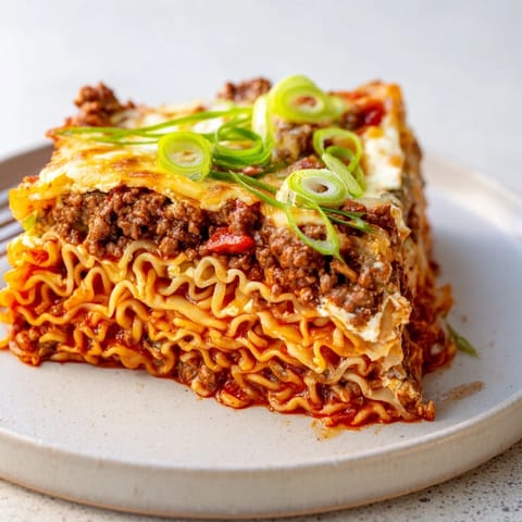 Delicious Spicy Ramen Lasagna crafted with rich ground pork and tangy tomato sauce.  