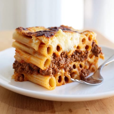 Creamy Greek Pastitsio layered with spiced beef and pasta, baked golden brown.  
