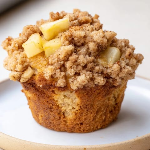Freshly baked, fragrant tasty apple muffins ready to serve with a delightful crumb topping.