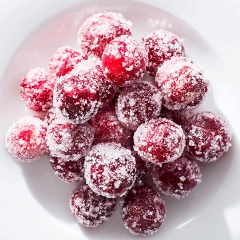 Vibrant image shows glistening vegan candied cranberry garnish, a perfect sweet, festive topping.