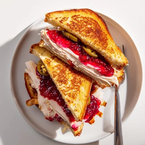 Spicy-sweet Air Fryer Jalapeño Cranberry Turkey Grilled Cheese, featuring turkey, jalapeño, and a gooey cheese pull.