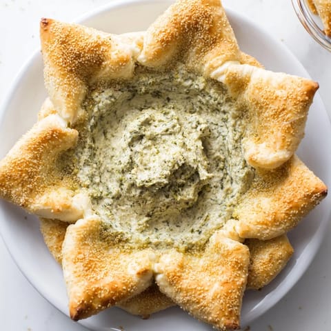 A beautiful star shape made of puff pastry cradles the fresh pesto dip, perfect for parties.
