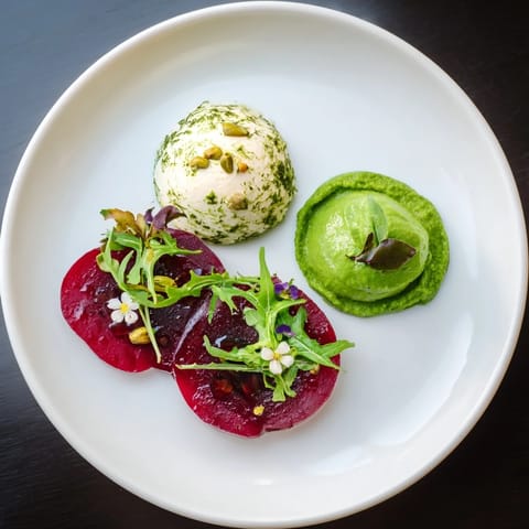 Elegant Lucky Clover Seasonal Starters, with vibrant green pea, beet, and goat cheese on a white plate.