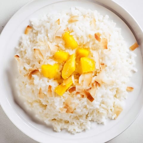 Creamy and fragrant coconut rice sweet, served warm with vibrant tropical fruit toppings.