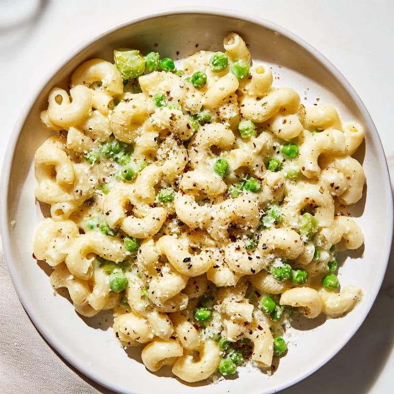 Bright green peas and tender macaroni tossed in a light sauce, ready to serve and enjoy.