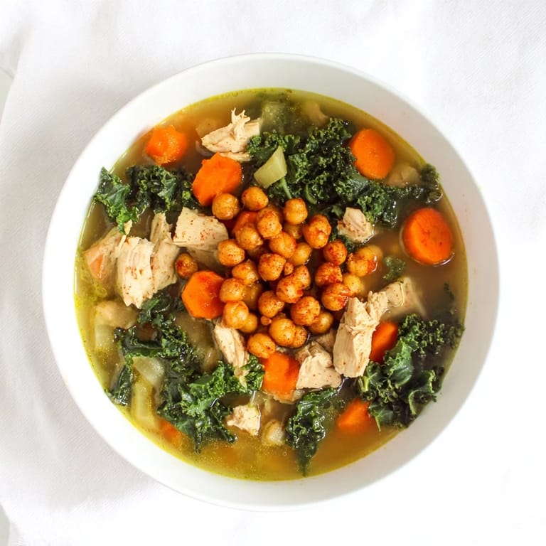 Close-up of the flavorful Chicken Kale Soup, topped with crunchy chickpeas; a comforting American classic.