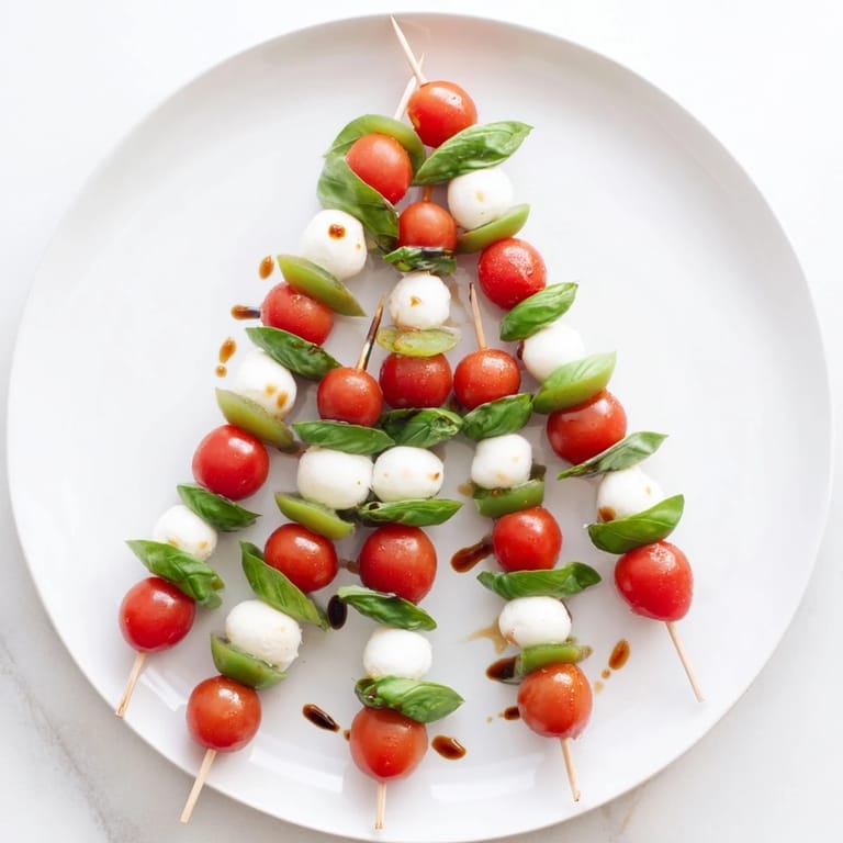 Festive Caprese Skewer Tree, showcasing juicy tomatoes, mozzarella, and fragrant basil ready to serve.