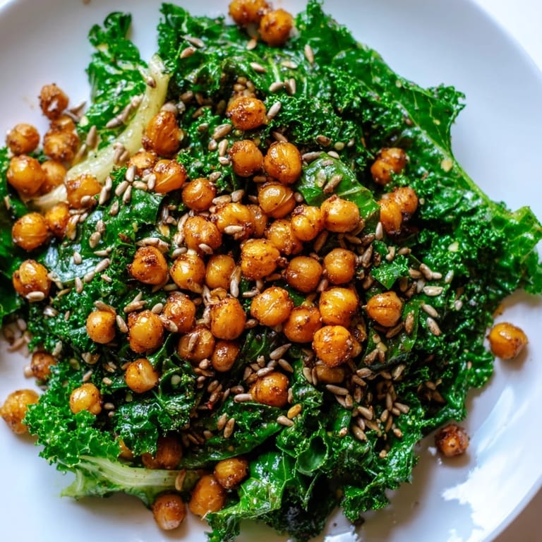 A flavorful Warm Kale Salad showcases vibrant greens and crunchy chickpeas drizzled with lemon dressing.
