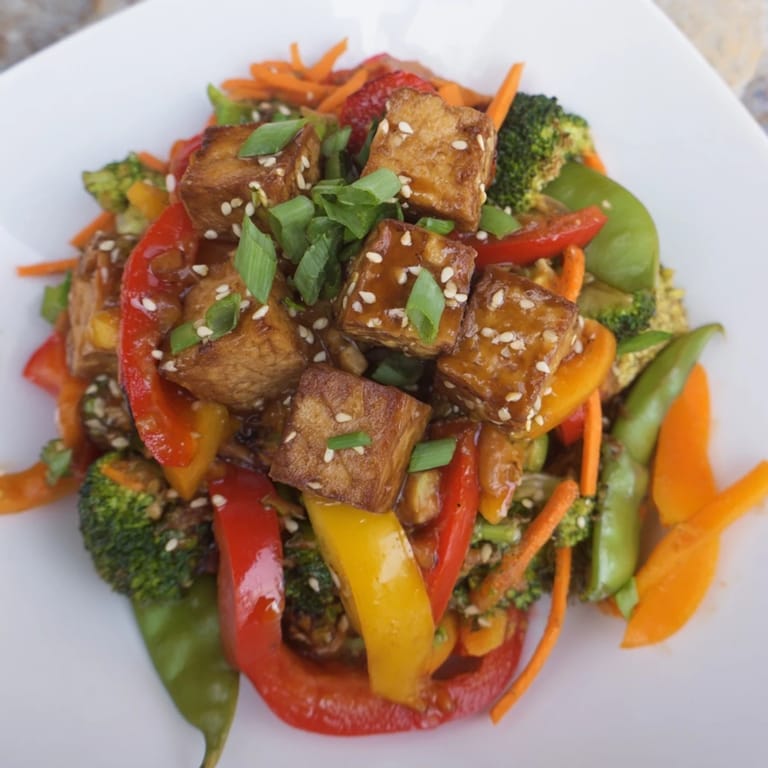 A close-up of Vegetable Tempeh Stir-Fry, showcasing broccoli, bell peppers, and snap peas tossed with protein-rich tempeh.