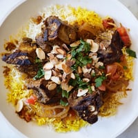 Golden-brown Qatari Majboos, with tender lamb atop fluffy spiced basmati rice, ready to serve beautifully.