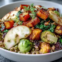 Autumn roasted squash and Brussels sprouts Fall Vegetable Bowl topped with kale and pepitas.